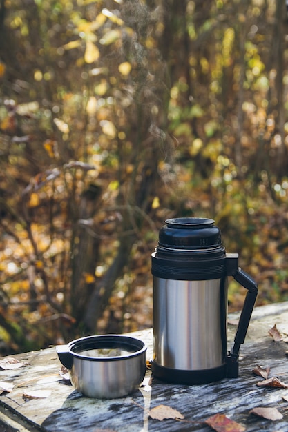 Foto hete thee en een thermoskan op de tafel in de herfst