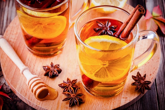 Hete thee met citroenanijs en kaneel in glazen mokken op houten tafel