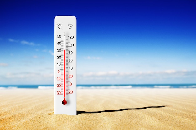 Hete zomerdag Celsius en Fahrenheit schaalthermometer in het zand Omgevingstemperatuur plus 33