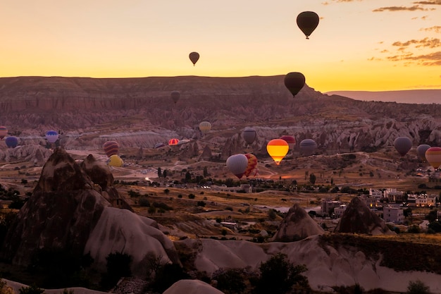 Heteluchtballonnen vliegen over een vulkanisch landschap in Cappadocië, Turkije