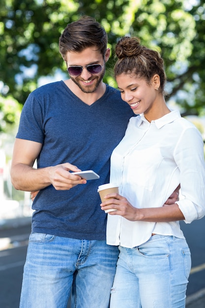 Heuppaar die smartphone int. Bekijken hij stad