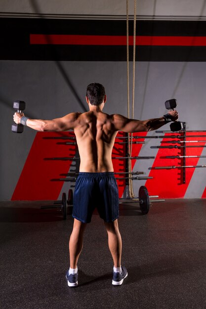 hex dumbbells man workout rear view at gym