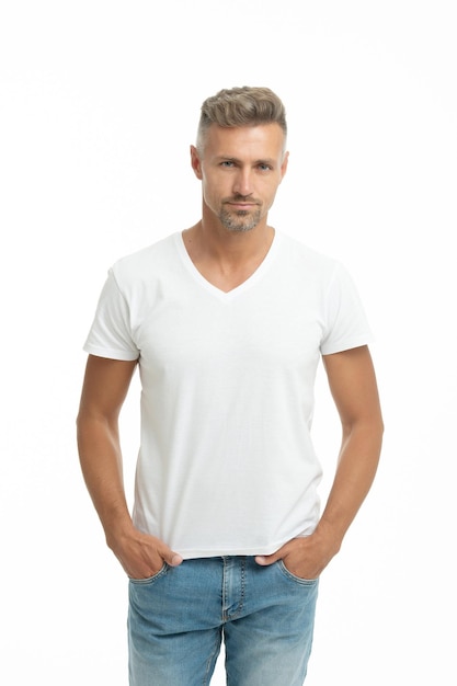 Hey, dude. Dude isolated on white. Handsome man in white tshirt. Unshaven guy keep hands in pockets. Adult male in causal.