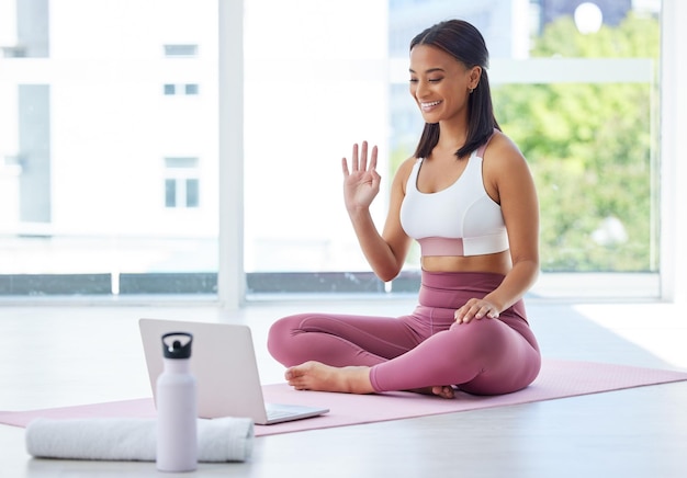 Hi everyone and welcome to another awesome session. Shot of a sporty young woman having a video call on a laptop in a yoga studio.