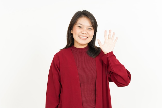 Ciao saluto o sventolando alla macchina fotografica di bella donna asiatica che indossa una camicia rossa isolata su bianco