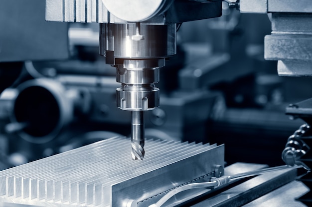 The Hi-precision CNC milling machine with cutting sample in blue-silver tone.The micro cutting technique in precision part.