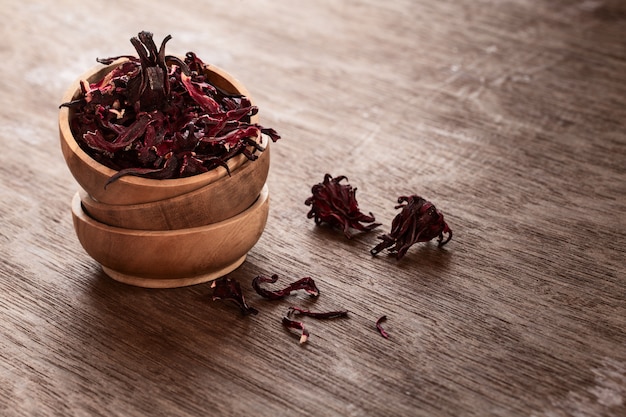 Hibiscus (Roselle, karkade) droge bloemen in bowles op houten achtergrond.