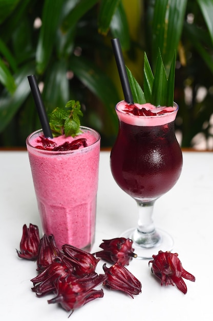 Hibiscus smoothie and ice tea on a white tableclose up