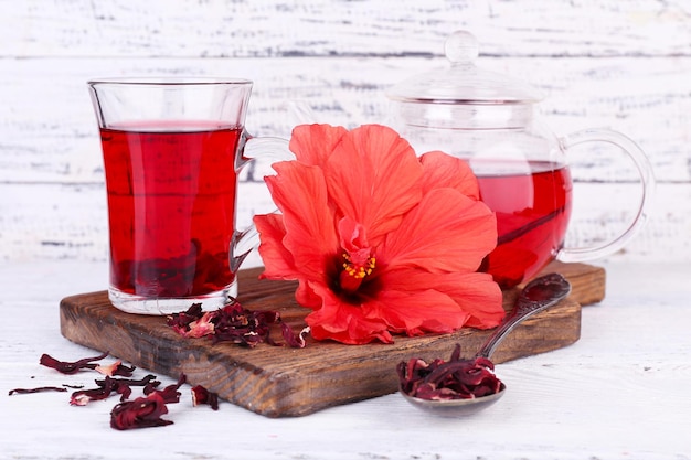 Hibiscus tea and flower on board on wooden background