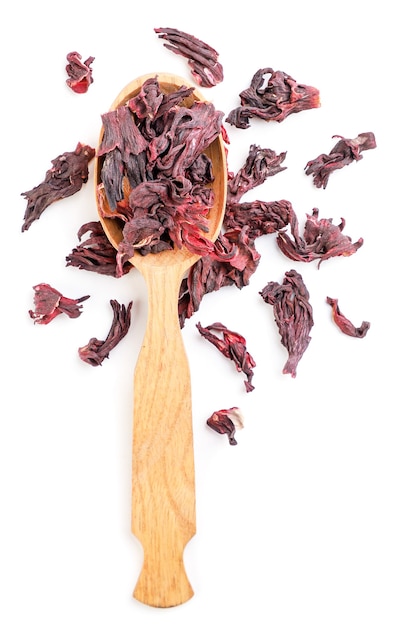 Hibiscus tea in a wooden spoon close-up on a white background, isolated. Top view