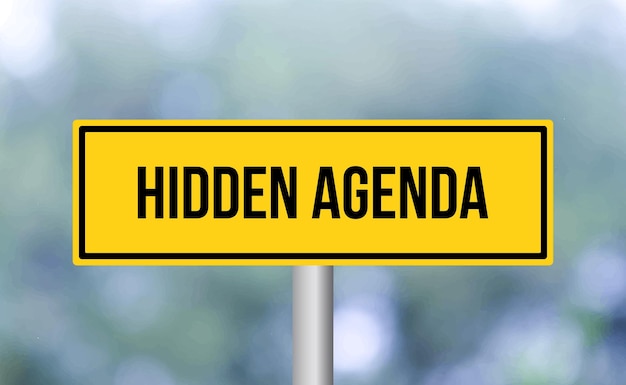 Hidden agenda road sign on blur background