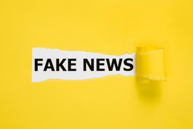 Photo hidden fake news words behind yellow paper