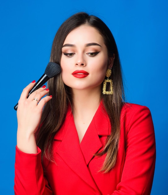 Hiding all imperfections Perfect skin tone Makeup artist concept Looking good and feeling confident Gorgeous lady makeup red lips Fashion model tv host Attractive woman applying makeup brush