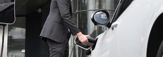 Hieronder weergave close-up progressieve zwart pak zakenman opladen batterij van EV auto