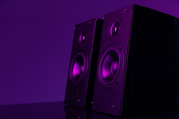 Акустическая система Hi-Fi с большими динамиками на темном фоне с фиолетовой неоновой подсветкой