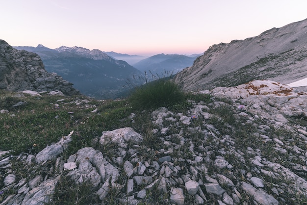 Terreno estremo ad alta quota, picco di montagna rocciosa e cresta frastagliata, con scenografico cielo tempestoso drammatico.