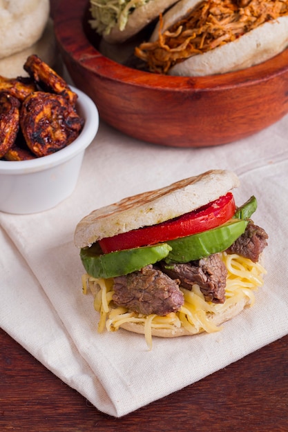 high angle of arepa with tomato and meat