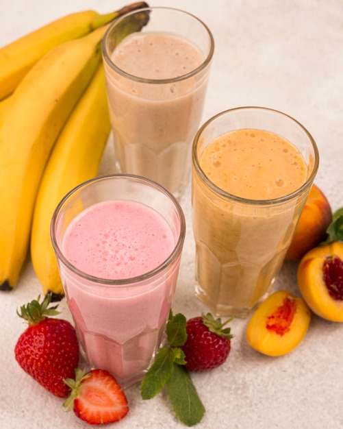 Photo high angle of assortment of milkshakes with bananas and strawberries