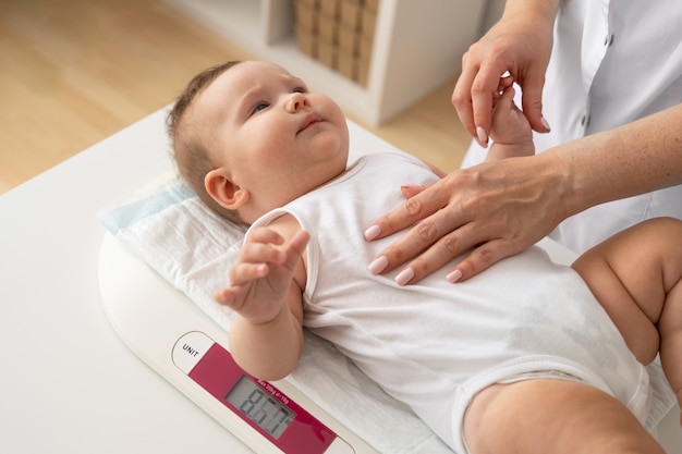 Bambino ad alto angolo che si posa sulla macchina di ponderazione