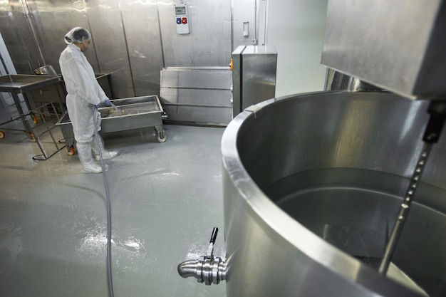 クリーン食品製造工場、コピースペースで機器を洗う女性労働者の高角度の背景画像