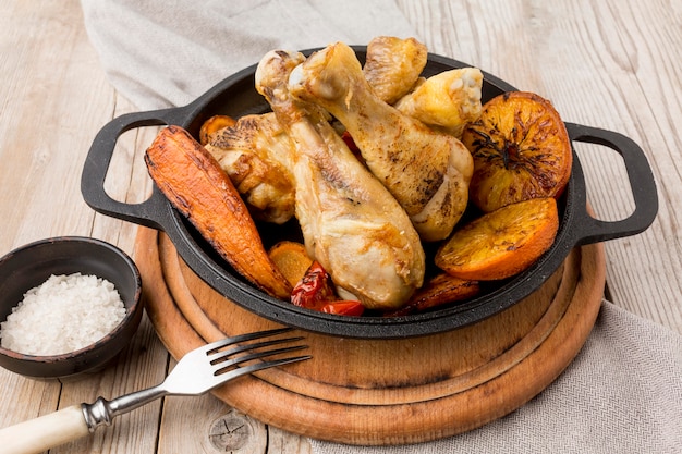 High angle baked chicken and veggies in pan with fork