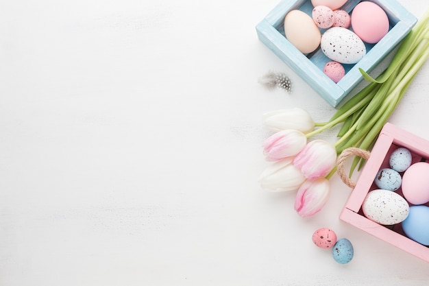 High angle of beautiful tulips with colorful easter eggs