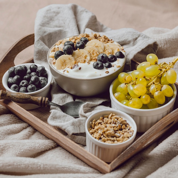 High angle of breakfast in bed with cereal and grapes