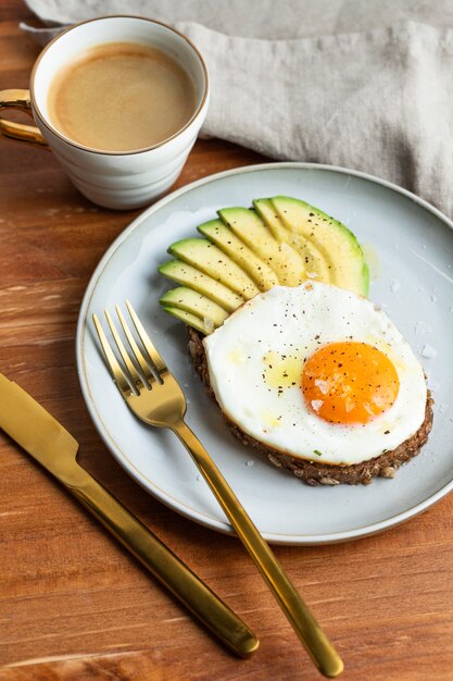 High angle of breakfast fried egg on plate with avocado