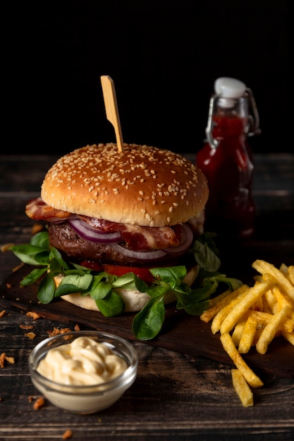 High angle burger and fries with sauces on table