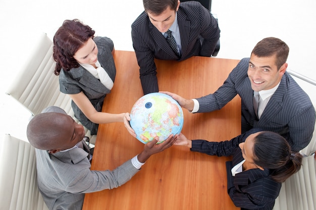 Photo high angle of businessteam holding a globe and businessman smiling upwards.