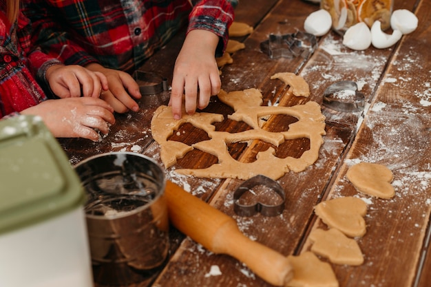 High angle children making cookies together at home