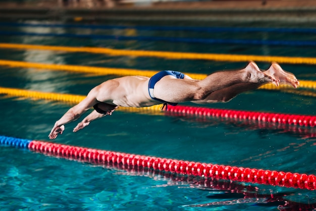 Foto salto di tuffo dell'angolo alto nella piscina