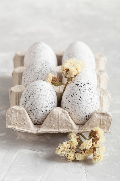 Photo high angle of eggs for easter in carton with flowers