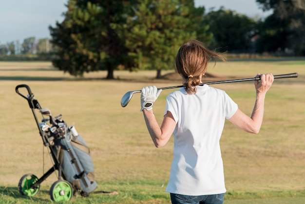 Femmina dell'angolo alto che gioca golf