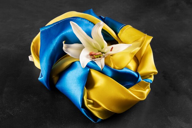 High angle folded ukranian flag and lily