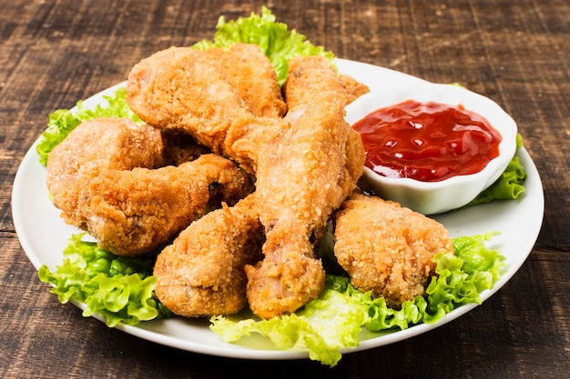 Photo high angle of fried drumsticks with ketchup