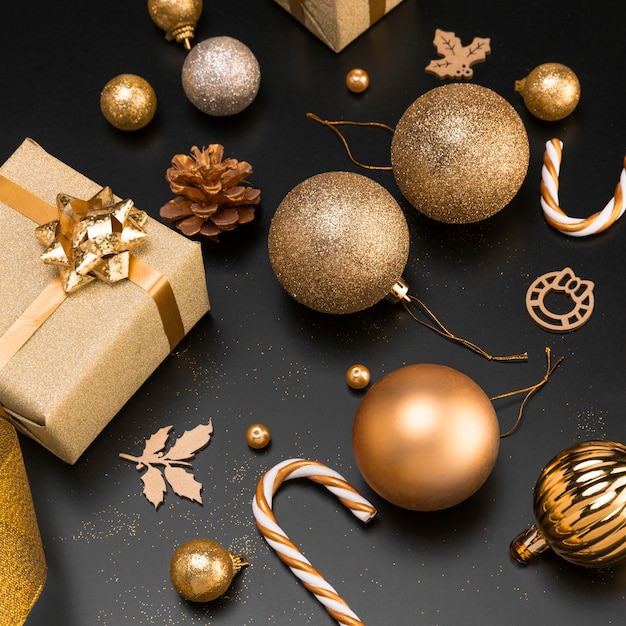 High angle of golden christmas ornaments with present and candy cane