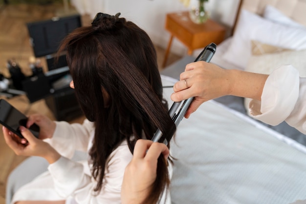 Mani ad alto angolo che sistemano i capelli della sposa