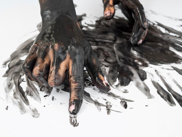 High angle of hands with black paint