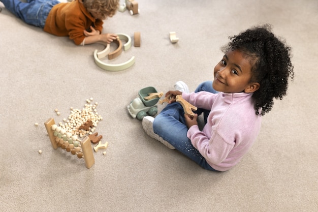 Photo high angle kids playing with ecological toys