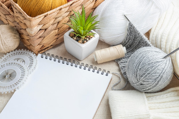 high angle of knitting set with yarn and notebook