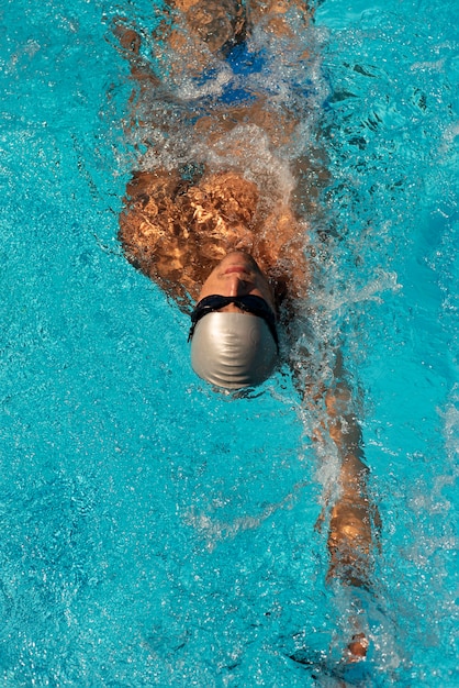 Alto angolo del nuotatore maschio che nuota nella piscina