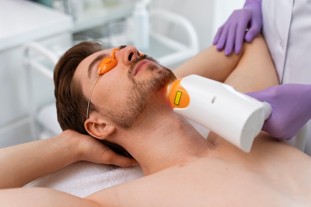 Photo high angle man at laser hair removal clinic