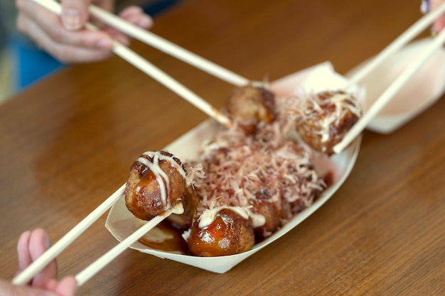 Photo high angle people eating with chopsticks