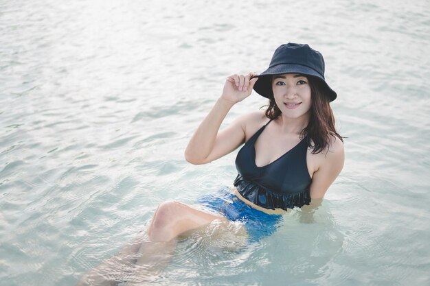 High angle portrait of beautiful woman sitting in sea