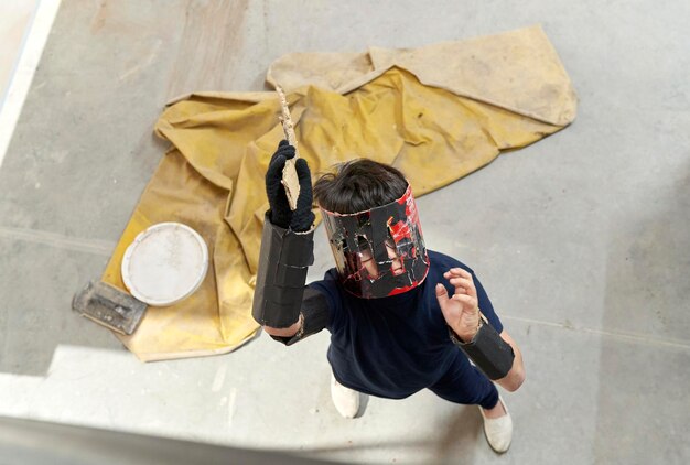 High angle portrait of boy holding cardboard sword at home