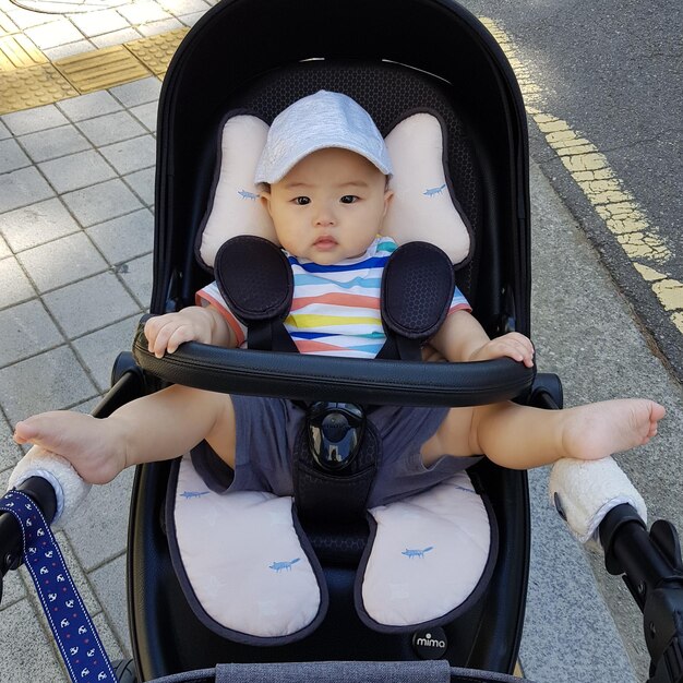 Photo high angle portrait of cute baby boy lying in stroller