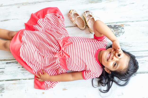 High angle portrait of cute girl lying on hardwood floor