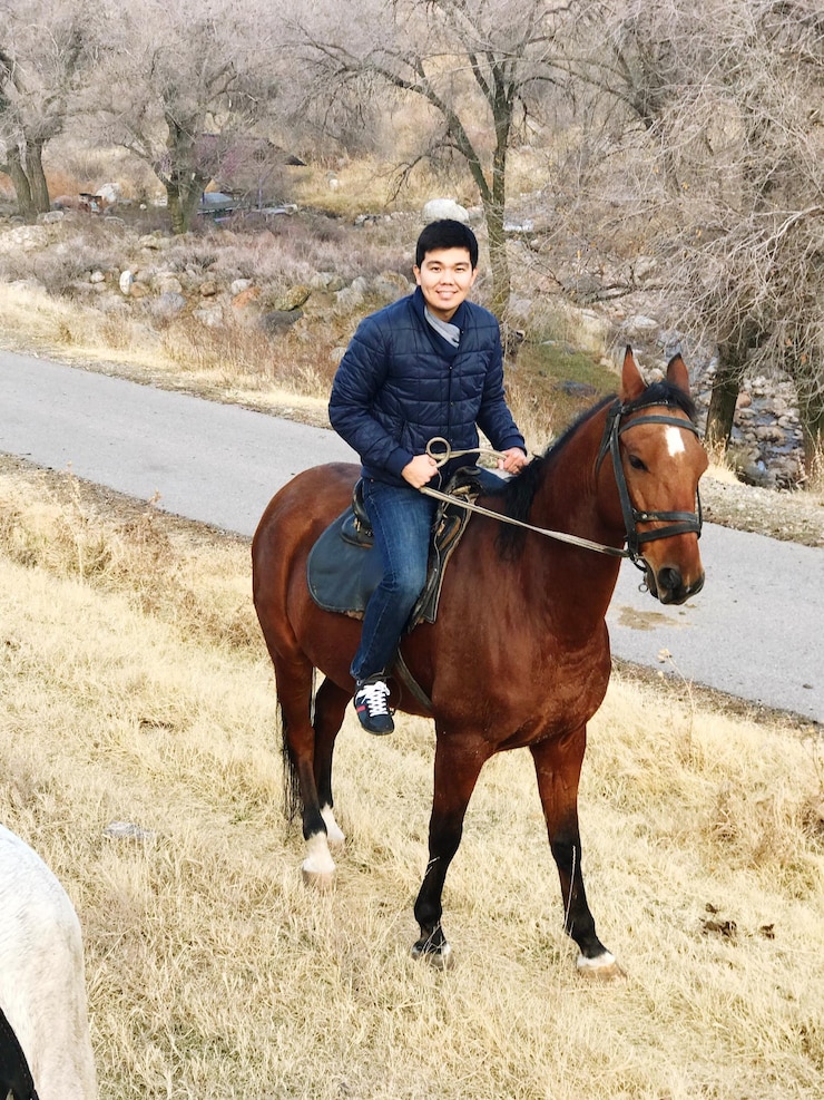 Photo 野原で馬に乗っている男の高角度の肖像画