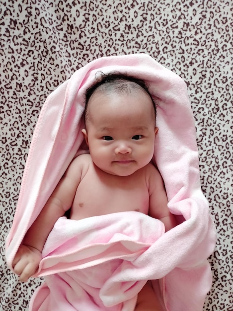 사진 침대에 누워있는 담요를 가진 귀여운 아기 소녀의 높은 각도 초상화